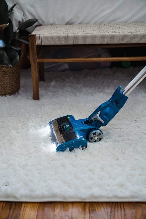 Free Blue Vacuum Cleaner on White Fur Carpet Stock Photo